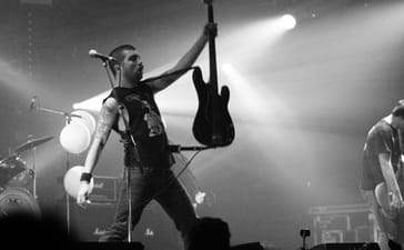 Converge bassist Nate Newton raises his bass overhead during the band’s 2007 performance at Eurockéennes in France.