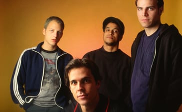 Four members of Quicksand posing against an orange background.