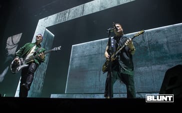 Avenged Sevenfold musicians performing in front of large angular stage screens