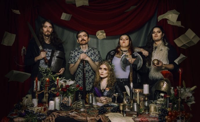 Boudicca bad image featuring the band members sitting at a table