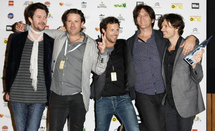 Powderfinger’s five members posing together with an award at the 2010 ARIA Awards.