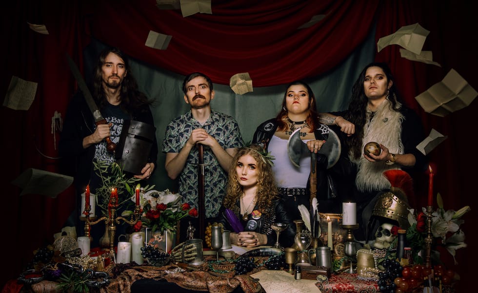 Boudicca bad image featuring the band members sitting at a table