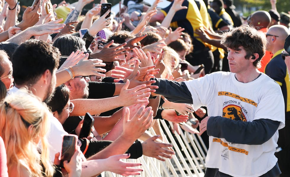 Turnstile’s Brendan Yates reaches towards fans across a crowd barricade.