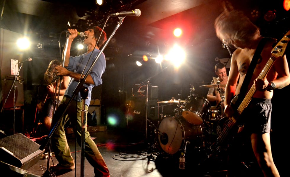 A wide-shot of the band performing on a small stage with bright lighting, taken on 1 October 2018.