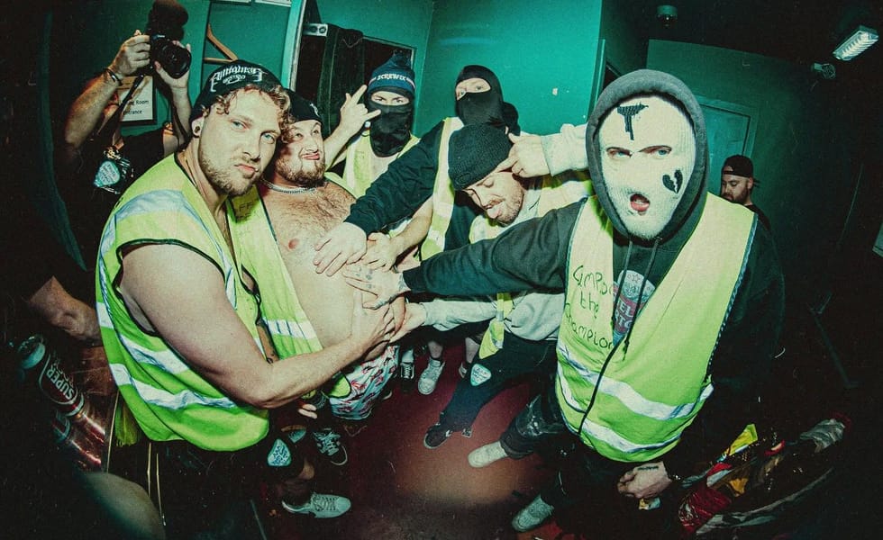 PINTGLASS posing together in fluorescent hi-vis vests, with several members wearing balaclavas.