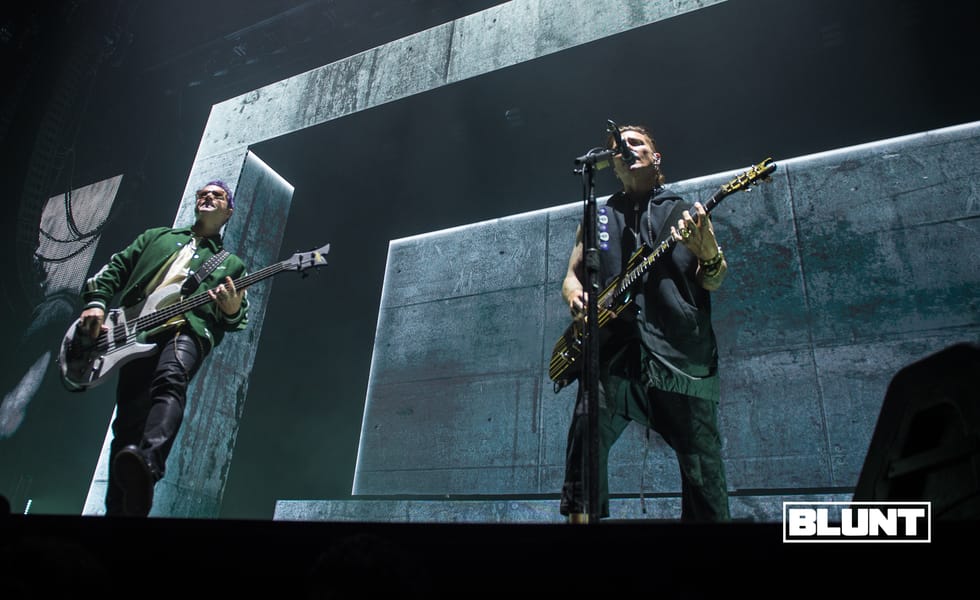Avenged Sevenfold musicians performing in front of large angular stage screens